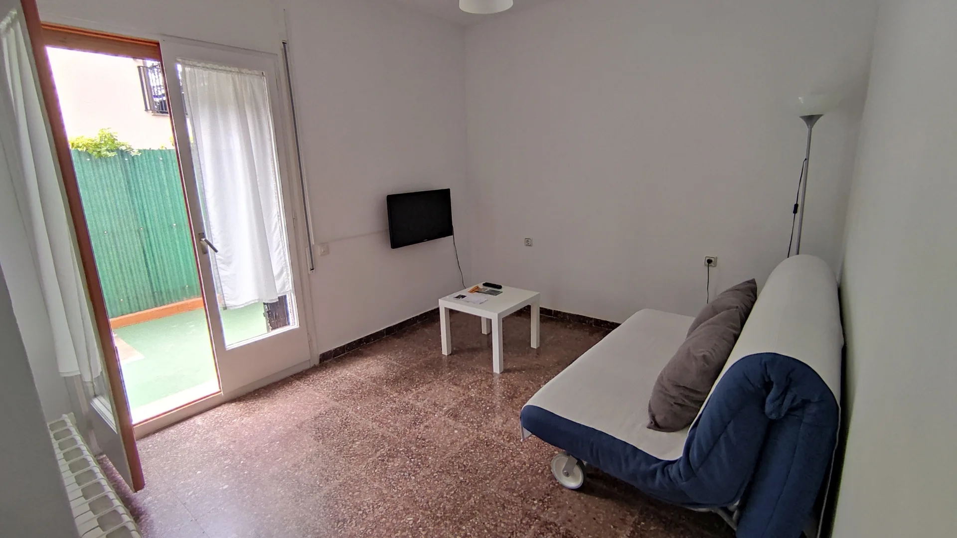 Sala de estar luminosa con sofá y salida al exterior